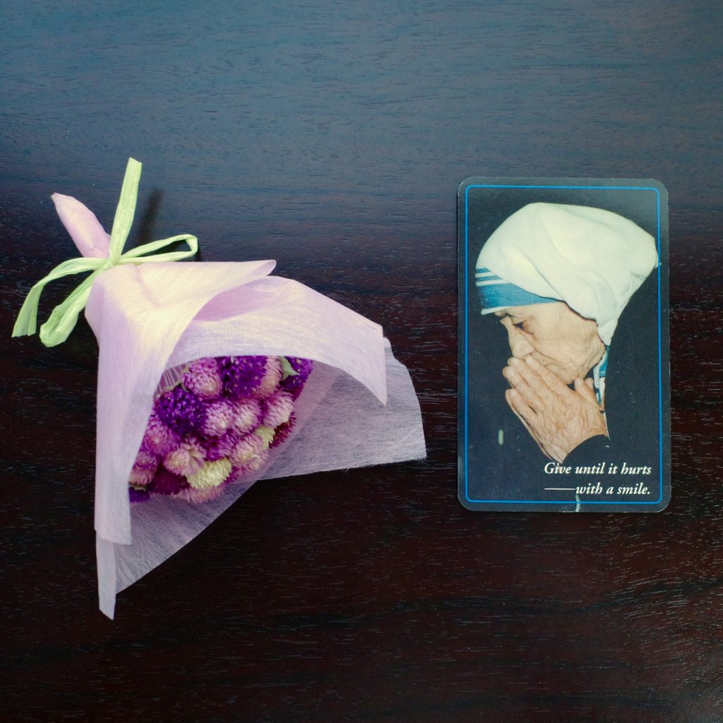 マザー・テレサのカード。名刺サイズ。"Give until it hurts ──with a smile"と書かれている。
