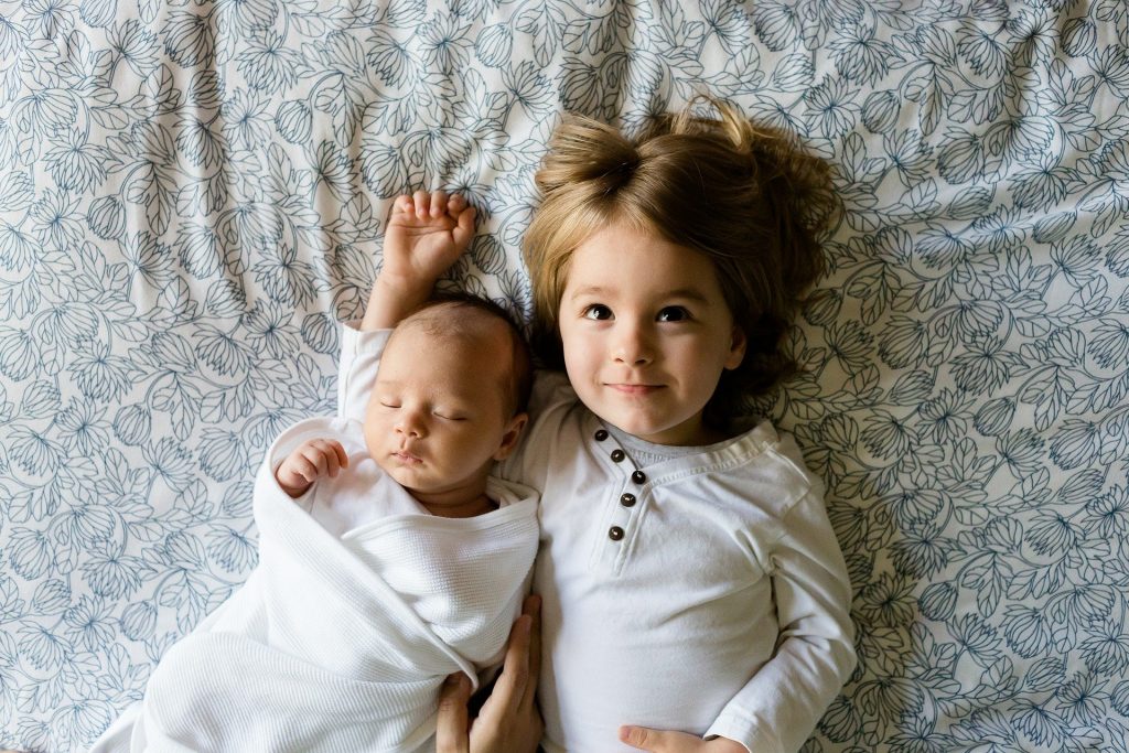 赤ん坊と女の子の姉妹ベッドで寝ている