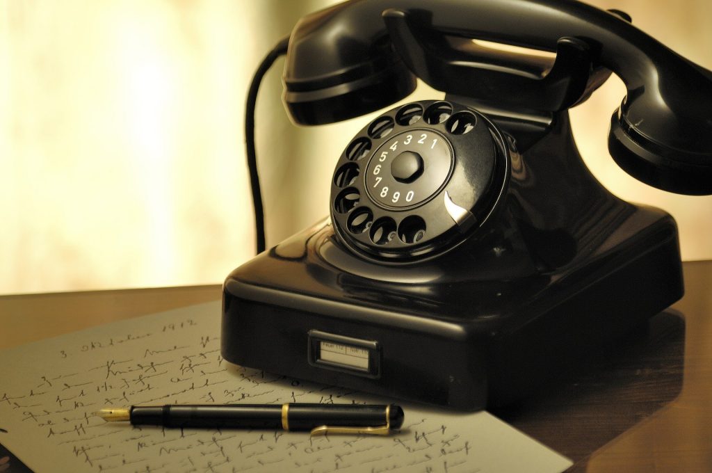 黒電話の前に万年筆とメモが置いてある。